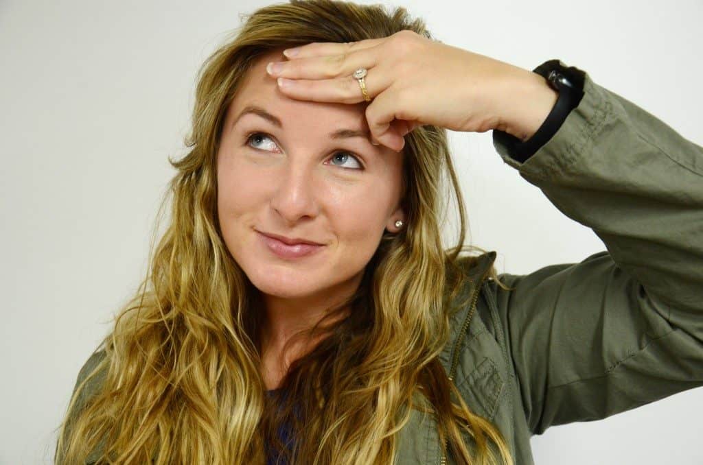 A woman that is holding her hand on her forehead