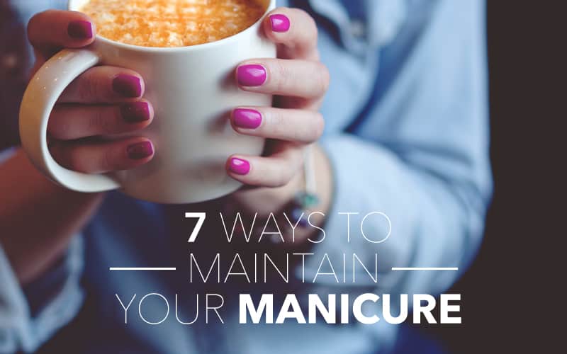 A woman with a manicure is holding a cup of coffee