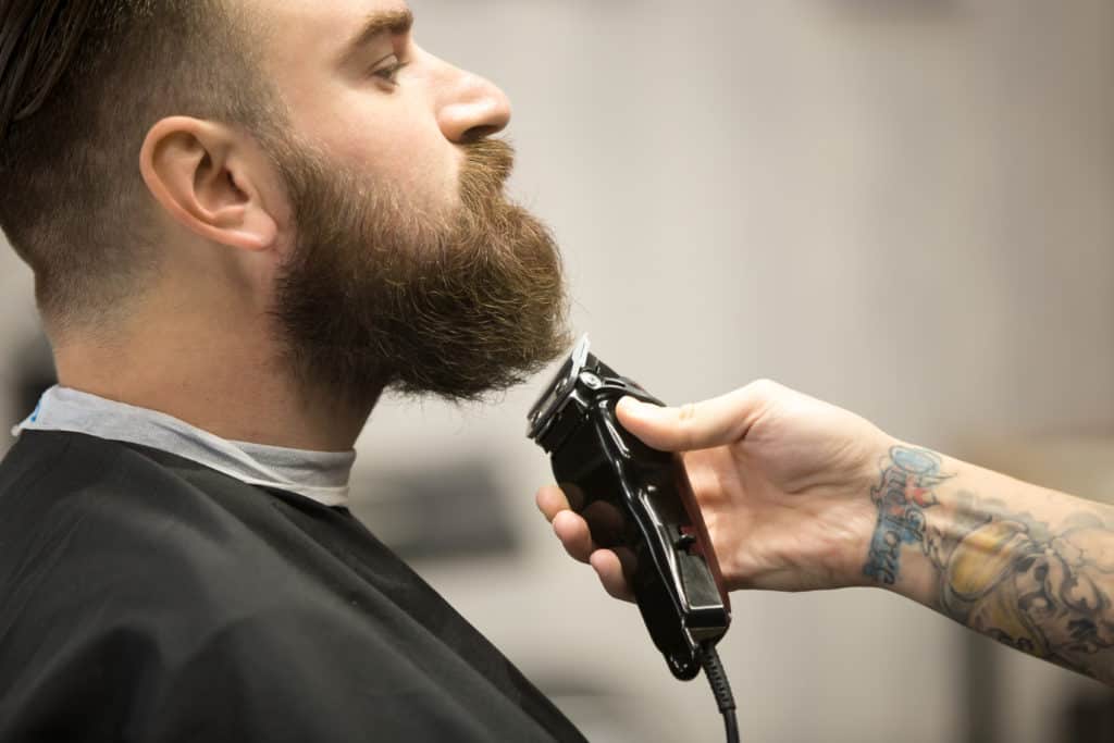 A man getting a facial hair cut