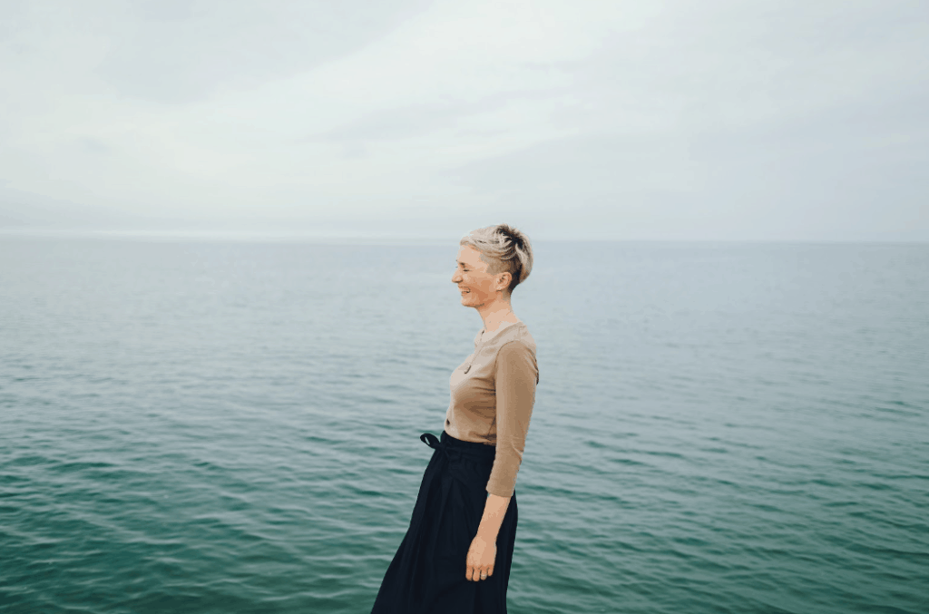 A woman is standing by the lake
