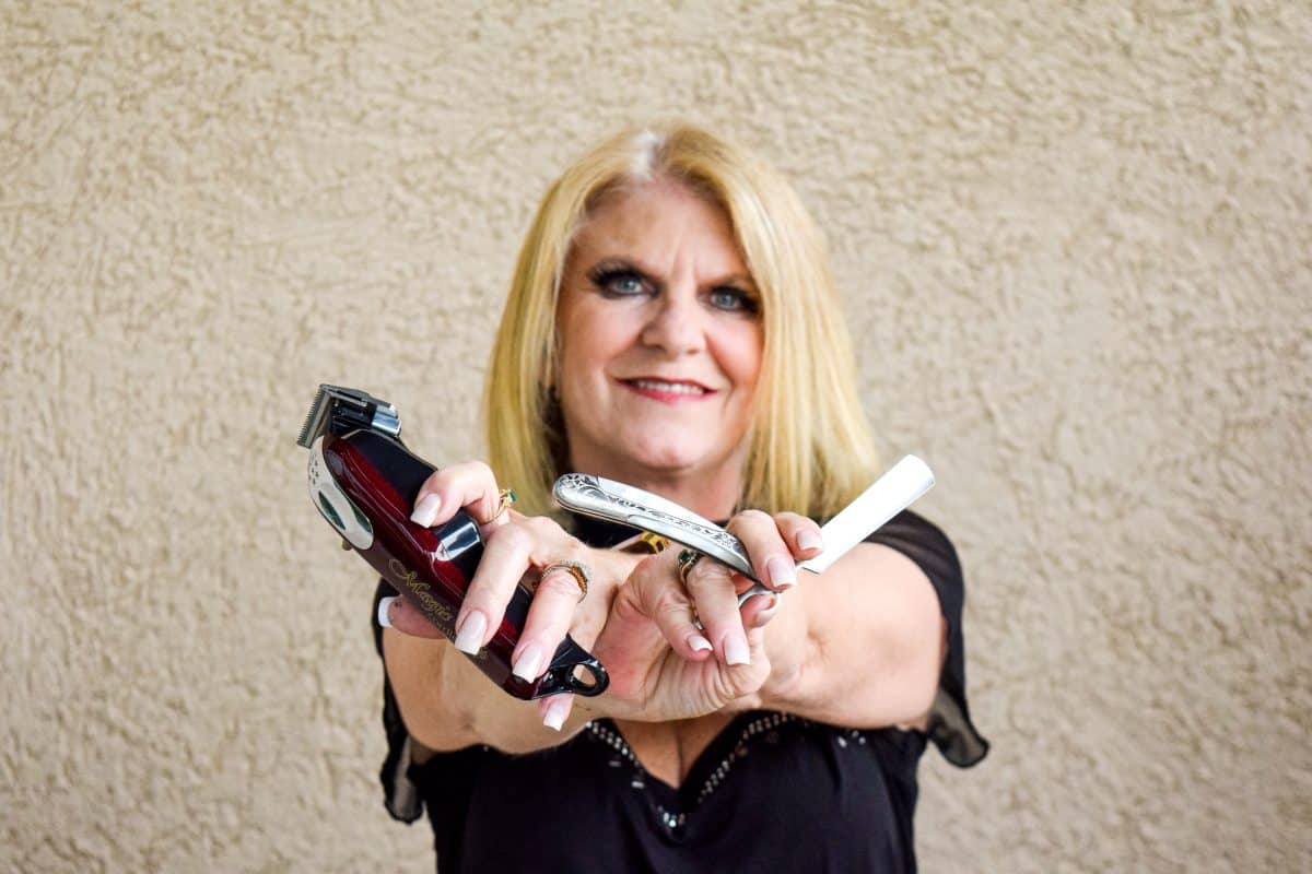 Female barber with blond hair and brber cutters